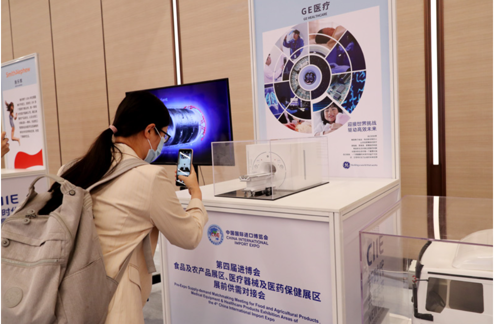 第四屆進(jìn)博會食品及農(nóng)產(chǎn)品展區(qū)、醫(yī)療器械及醫(yī)藥保健展區(qū)展前供需對接會的參會嘉賓用手機(jī)拍攝參展企業(yè)的展品模型